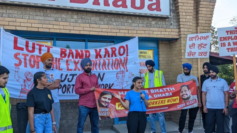 Restaurant worker from Baba Dhaba addressing NSN crowd at protest in July 2022. Banner behind her arguing for ending wage theft / exploitation